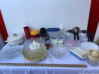 Overview of assorted glassware, plastic storage, coffee carafes, juicer, casserole