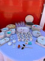Overview of plates, napkin rings, crystal glasses, platters, metal rose and tealight