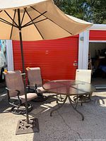 Lot overview showing table, three chairs, umbrella and base