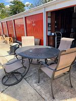 Round lattice metal table with two chairs visible