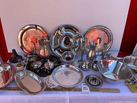 Overall lot view with trays, bowls, tea set, candlesticks, vase