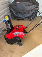 Left side view of Toro Power Clear 518 ZE snow blower showing full unit, wheels, handle, and chute