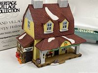 Front view of Van Tassel Manor porcelain building with box in background