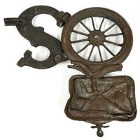 Front view of spoked wheel, letter S and satchel components