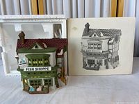 Front view of porcelain building next to styrofoam insert and outer sleeve