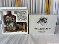 Lighted building in open Styrofoam next to outer sleeve