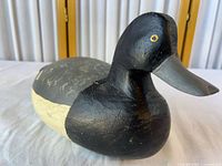 Left front view of carved wooden duck decoy showing head, bill and paint scheme
