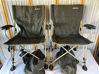 Pair of Maccabee folding camping chairs unfolded with carry bags beneath