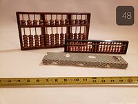 Large and small abacuses with sleeve and measuring tape for scale