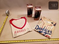 Full lot: two boxed bobbleheads, folded Angels T-shirt, bagged Dodgers Betts T-shirt with measuring tape for scale