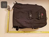 Front view showing Lowepro logo, dual front buckles, tape measure illustrating width and length