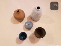 Top view of five ceramic vessels showing shapes and glazes