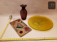 Overall view of yellow plate, purple vase, mosaic tile with tape measure for scale