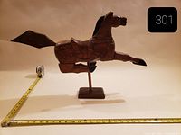 Full side view of wooden horse sculpture with measuring tape for scale