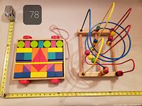 Pull cart block puzzle and bead maze displayed beside measuring tapes for scale