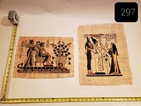 Both papyrus artworks laid flat with measuring tape for scale