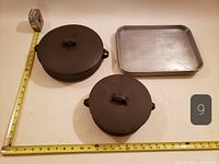 Top view showing both covered Dansk casseroles and one cafeteria tray with measuring tape for scale