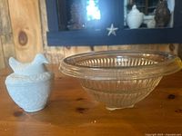 Avon milk glass bird dish next to clear pressed glass footed bowl