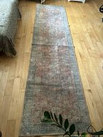 Full view of 3' x 10' distressed Persian style hallway runner rug on wood floor