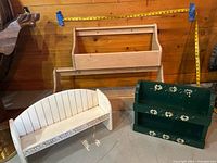 Group view of four wooden wall shelves: two natural finish, one white curved, one green painted