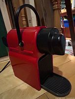 Side view of red Breville Nespresso Inissia machine with drip tray extended