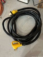 Coiled 25 ft Camco shore power cord showing both ends