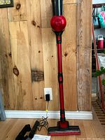 Vacuum assembled upright showing red wand, motor housing and floor head