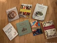 Seven books laid out on wooden floor