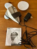 ObusForme PM-01 massager, two attachments, power adapter, manual on table