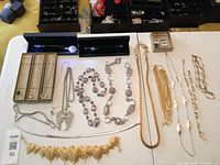 Overall view of all necklaces laid out on tables showing boxed pieces and assorted chains