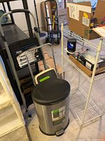 Overall lot showing trash can, white wire shelf with mosquito trap, step stools and ladders