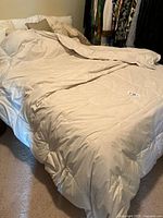 Comforter spread on bed showing size and color