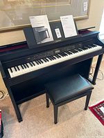 Front view of Casio AP-650 piano with keys exposed, manuals on music rest, bench in front