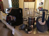 All main items on countertop: FlexBrew coffee maker, NutriBullet base with cups and accessories, Calla hydrogen pitcher, mugs visible