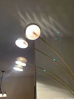 Four dome shades on curved brass arms