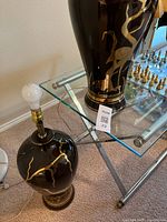 Two ceramic lamp bases, one with bulb and brass harp visible