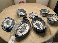 Entire set arranged on table showing bakers, bowls, plates, trivets, racks and lids