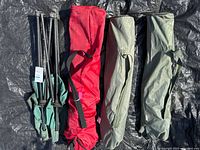 Three carry bags and one folded chair frame on tarp
