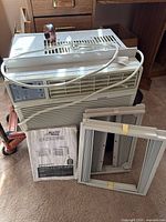 Full view of window AC with side panels and manual