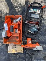 Overall view of both sanders in their cases with cords and accessories visible