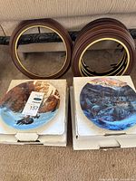 Two boxed collector plates and four wooden frames