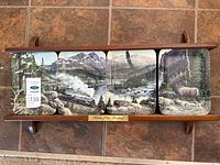 Overall view of four Heart of the Rockies plates in wooden frame