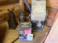 Loose rusted bottle jacks beside two boxes and blue handle