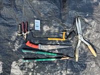 All seven garden cutting tools laid out on tarp