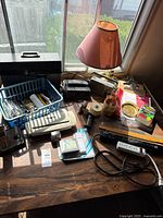 Wide view of desk with lamp, shredder, toolbox, basket and various supplies