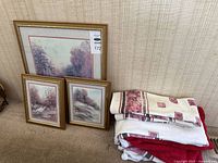 Group shot of three framed prints and stack of towels