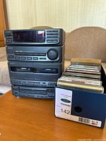 Front view of Sony MHC-610 component system stacked with box of CDs