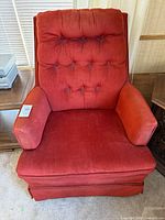 Front view of red tufted swivel rocker chair