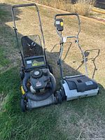 Overall view of Yard Machines mower and Yardworks dethatcher side by side outdoors