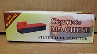 retail box front reading "Cigarette Machine Filter Tube Injector"